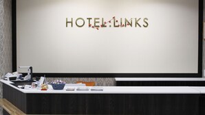 A reception desk with a sign reading "HOTEL LINKS" and a counter with various items including a basket, a phone, and some papers. - HOTEL.LINKS Dobutsuen-mae (Osaka)