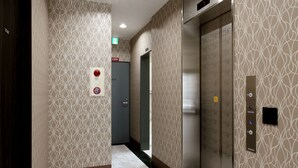 A hallway with patterned walls, a marble floor, and an elevator. - HOTEL.LINKS Dobutsuen-mae (Osaka)