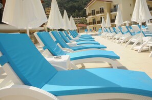 Una piscina al aire libre de temporada, sombrillas