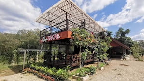 A two-story building with a covered outdoor area, surrounded by a gravel path and potted plants. - Krabi Avahill (Krabi)