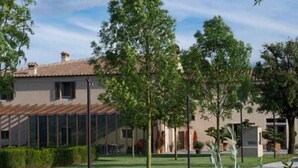 A residential area with a house featuring a tiled roof, a glass facade, and a well-maintained lawn.