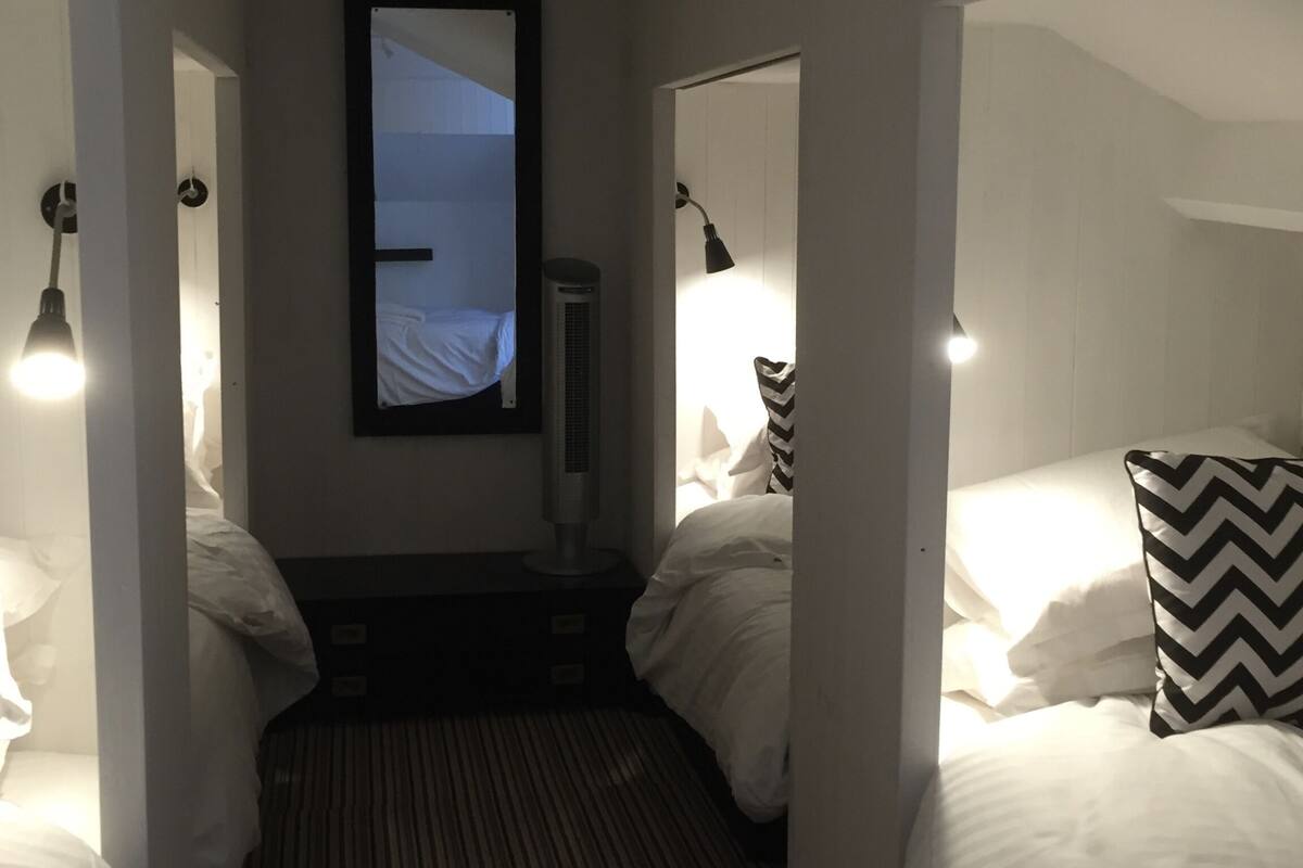 Une chambre d’hôtel avec deux lits, un radiateur mobile et une fenêtre donnant sur un paysage agréable.
