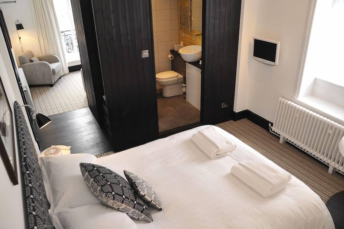 Une chambre d’hôtel avec un lit, une salle de bain et une vue sur l’extérieur.