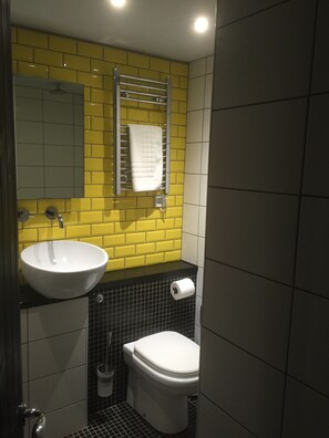 A bathroom with a white sink, a toilet, and a towel rack. - Greenbank Lodge Llangollen (Llangollen)