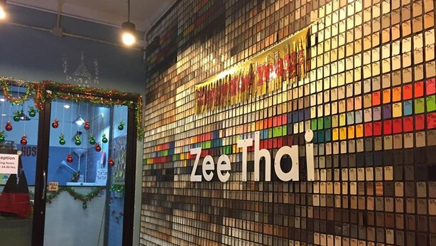 A wall with a grid of color samples and the text "Zee Thai". - Zee Thai Hostel (Bangkok)