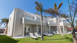 A modern hotel with a pool area, multiple balconies, and palm trees. - Hotel LIVVO Koala Garden (San Bartolomé de Tirajana)