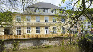 A yellow building with a sign reading "Hotel Restaurant Friedrichs" across the front. - Hotel Friedrichs (Schleiden)
