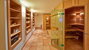 A hallway with wooden lockers, a bench, and a sauna area. - Hotel Friedrichs (Schleiden)