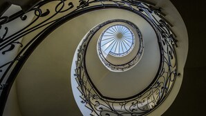 A spiral staircase with ornate metal railings and a skylight at the top. - S&L Boutique Hotel  (Tbilisi)