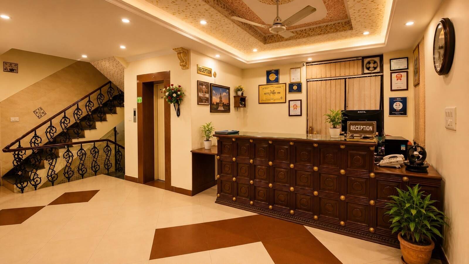A reception area with a reception desk, a staircase, and a ceiling fan.