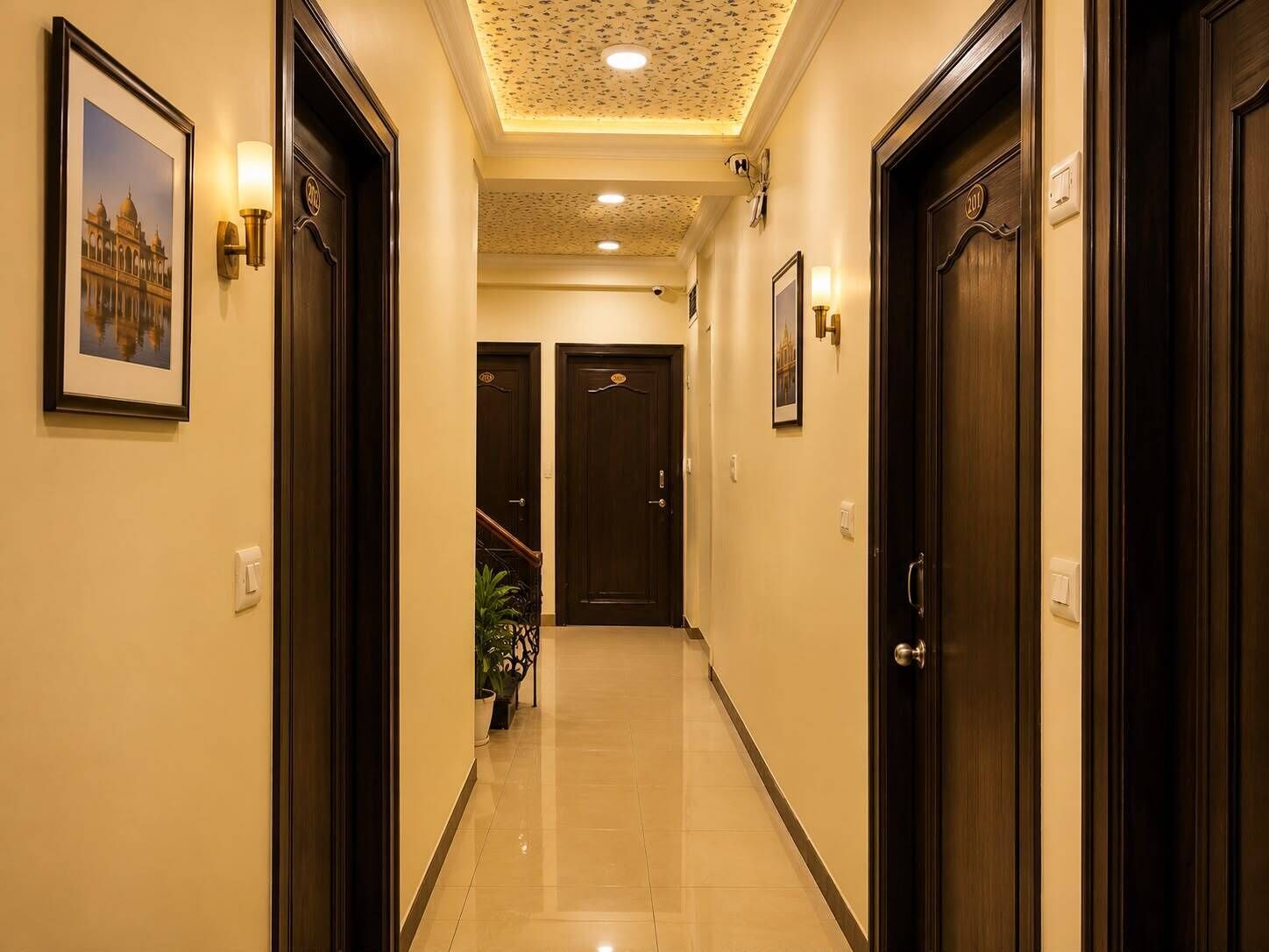A hallway with dark wooden doors, a tiled floor, and framed pictures on the walls.
