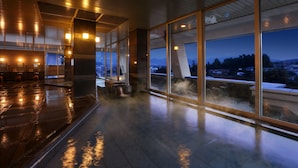 A spacious indoor area with large windows offering views of a cityscape and mountains at dusk. - Kaminoyama Azumaya (Kaminoyama)