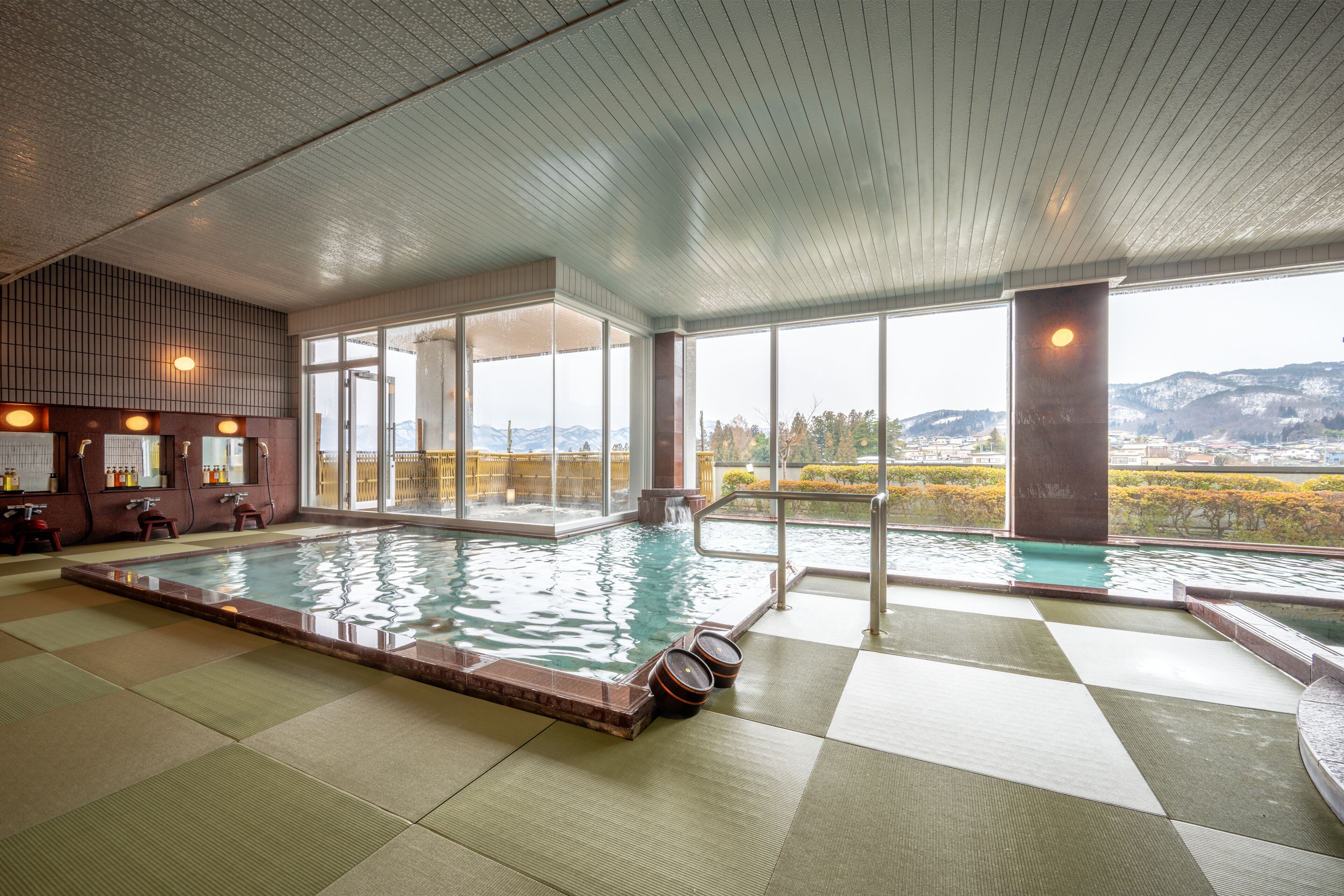 A large indoor swimming pool with clear views of mountains and a checkered floor.