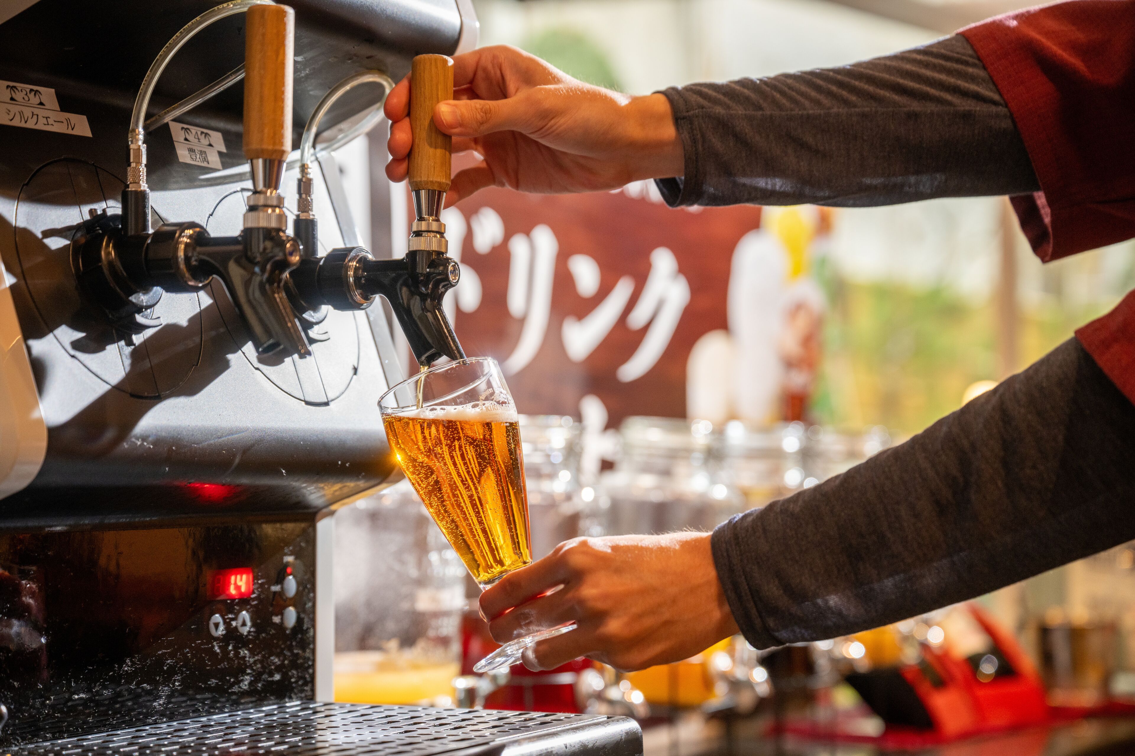 A person pouring beer from a tap into a glass.