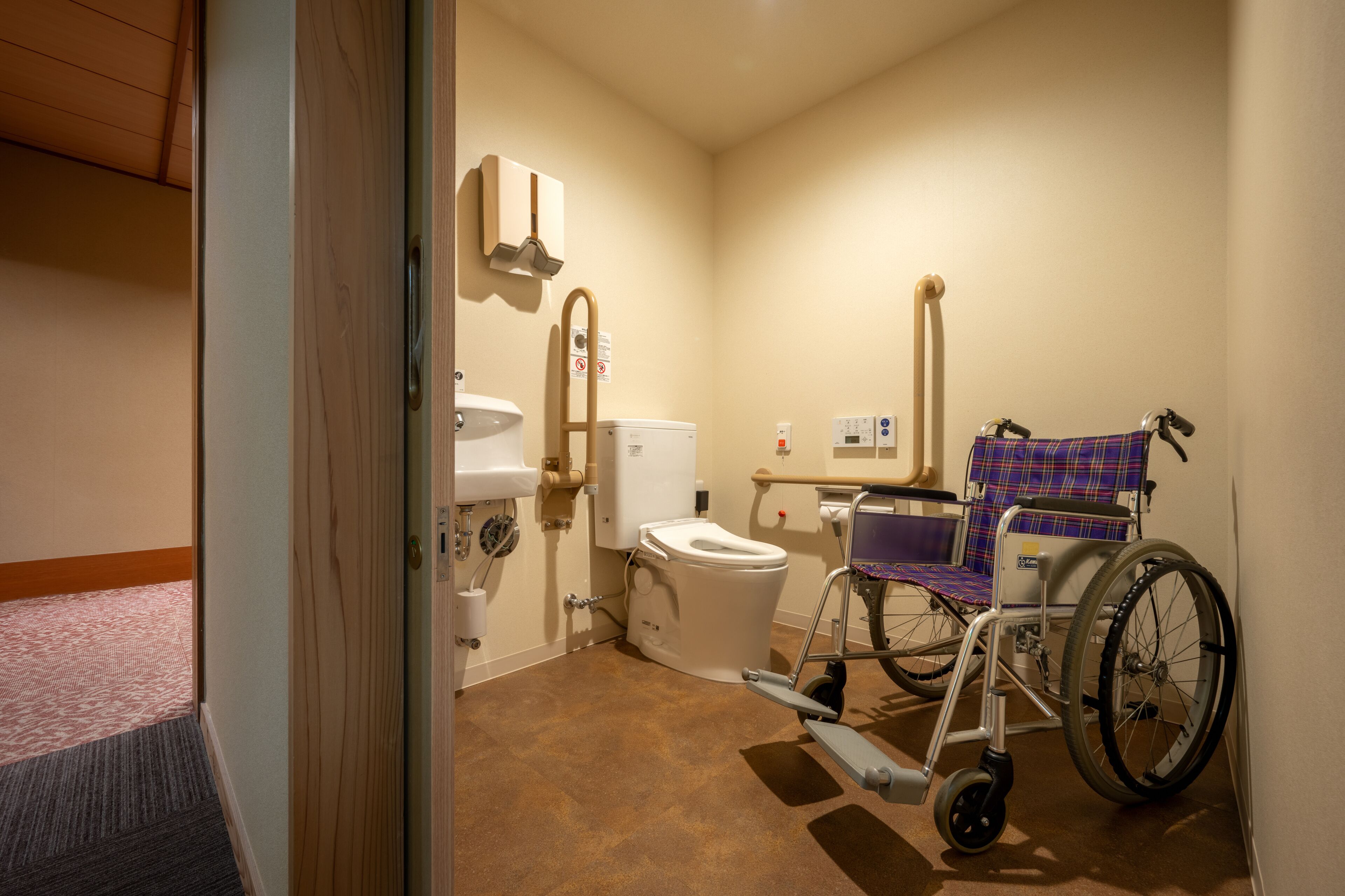 Des toilettes accessibles aux personnes en fauteuil roulant, équipées d’un WC, d’un lavabo et d’un sèche-mains.