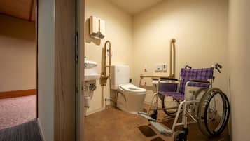 Des toilettes accessibles aux personnes en fauteuil roulant, équipées d’un WC, d’un lavabo et d’un sèche-mains.