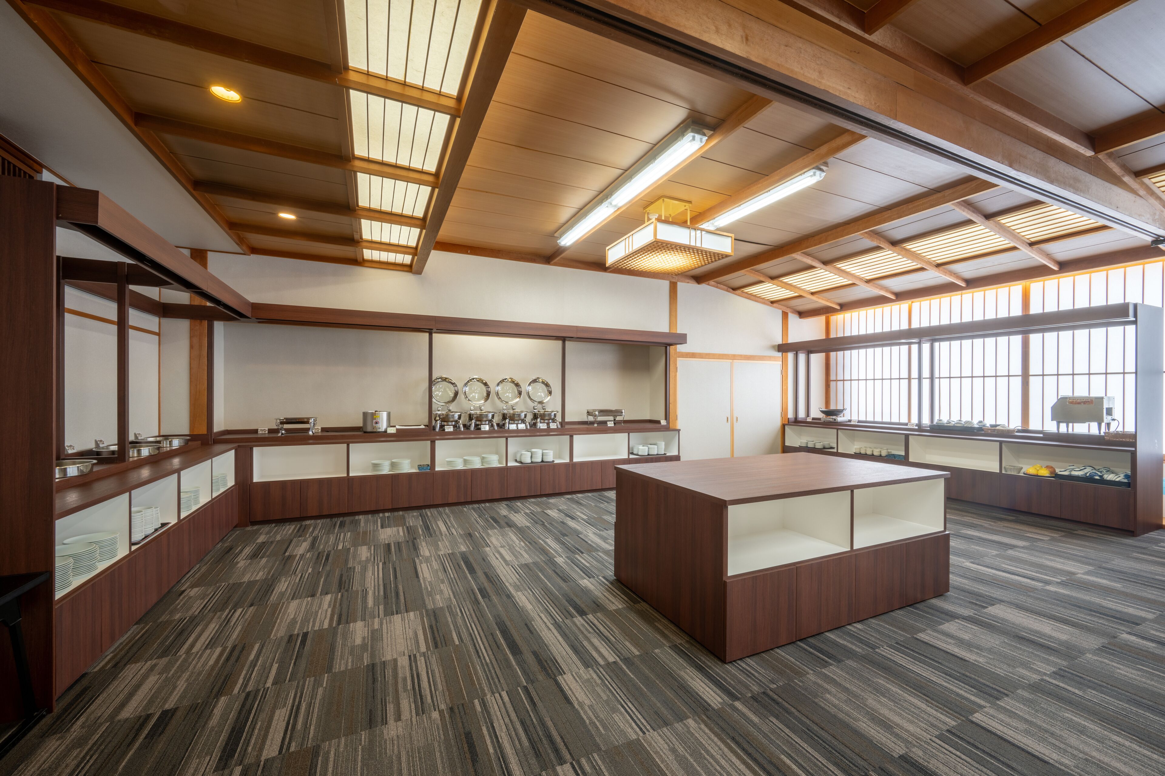 A modern kitchen with wooden cabinets, a central island, and a tiled floor.