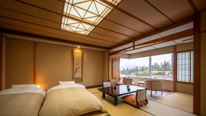 A traditional Japanese-style room with tatami flooring, a low table, and a sofa. - Kaminoyama Azumaya (Kaminoyama)