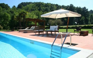 Una piscina al aire libre de temporada, sombrillas