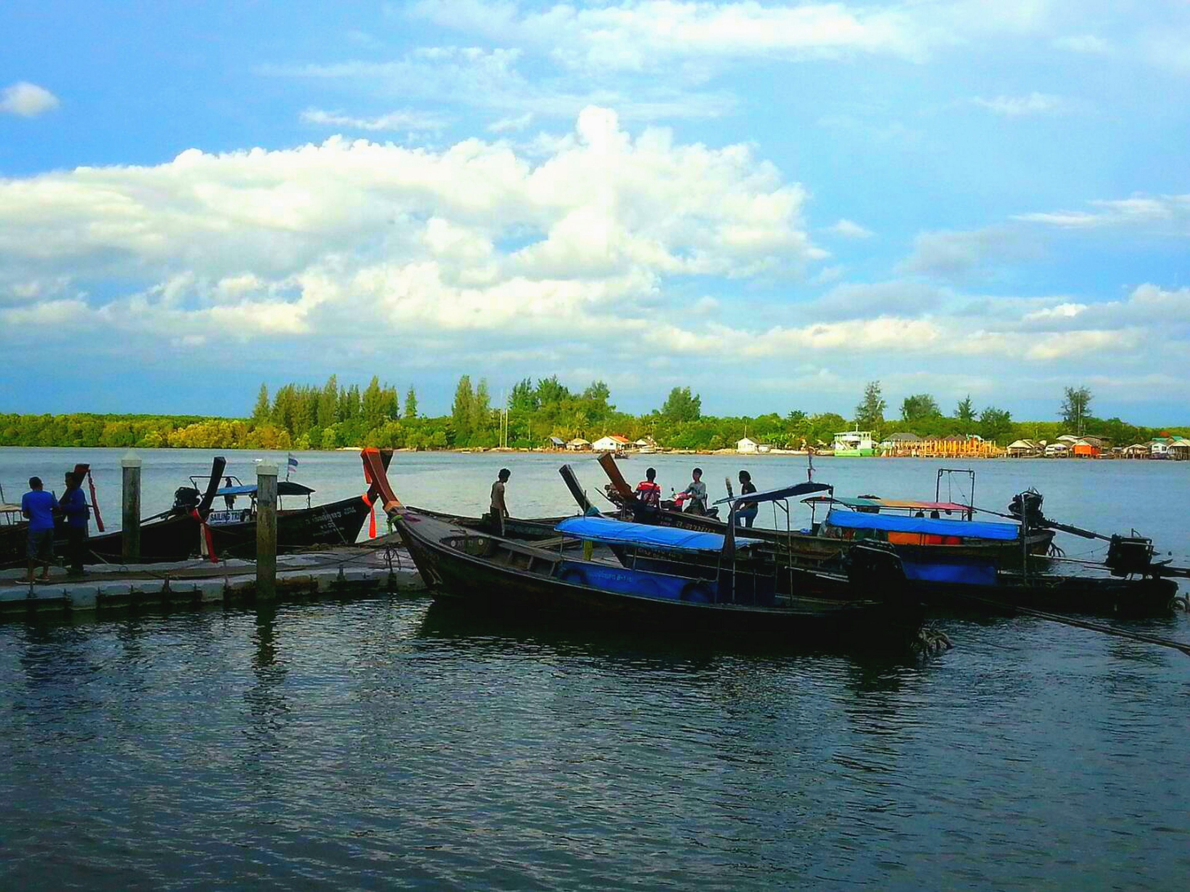 Un lago tranquilo con varios barcos amarrados en un muelle.