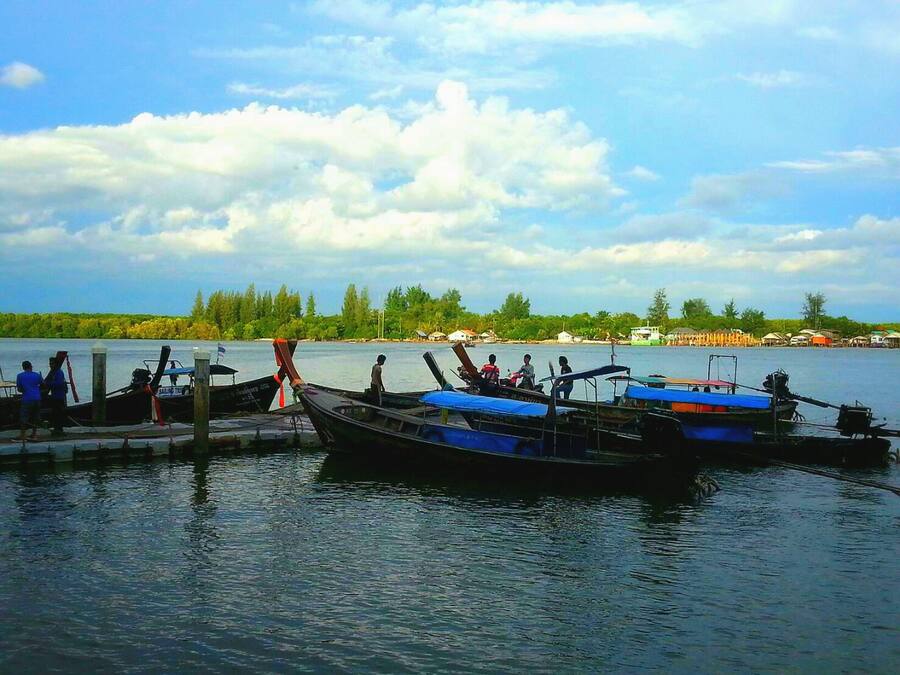 Un lago tranquilo con varios barcos amarrados en un muelle.