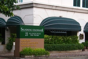 Une enseigne indiquant « Saladaeng Colonnade », et précisant que l’établissement propose des logements, des appartements avec services et un restaurant-café.