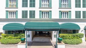 Un bâtiment avec des volets verts et une entrée abritée.