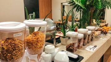 A breakfast buffet with various food options and utensils.