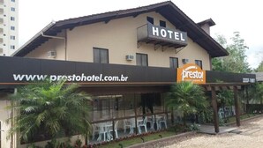A hotel with a balcony, outdoor seating, and a restaurant named 'Presto'. - Presto Hotel (Blumenau)