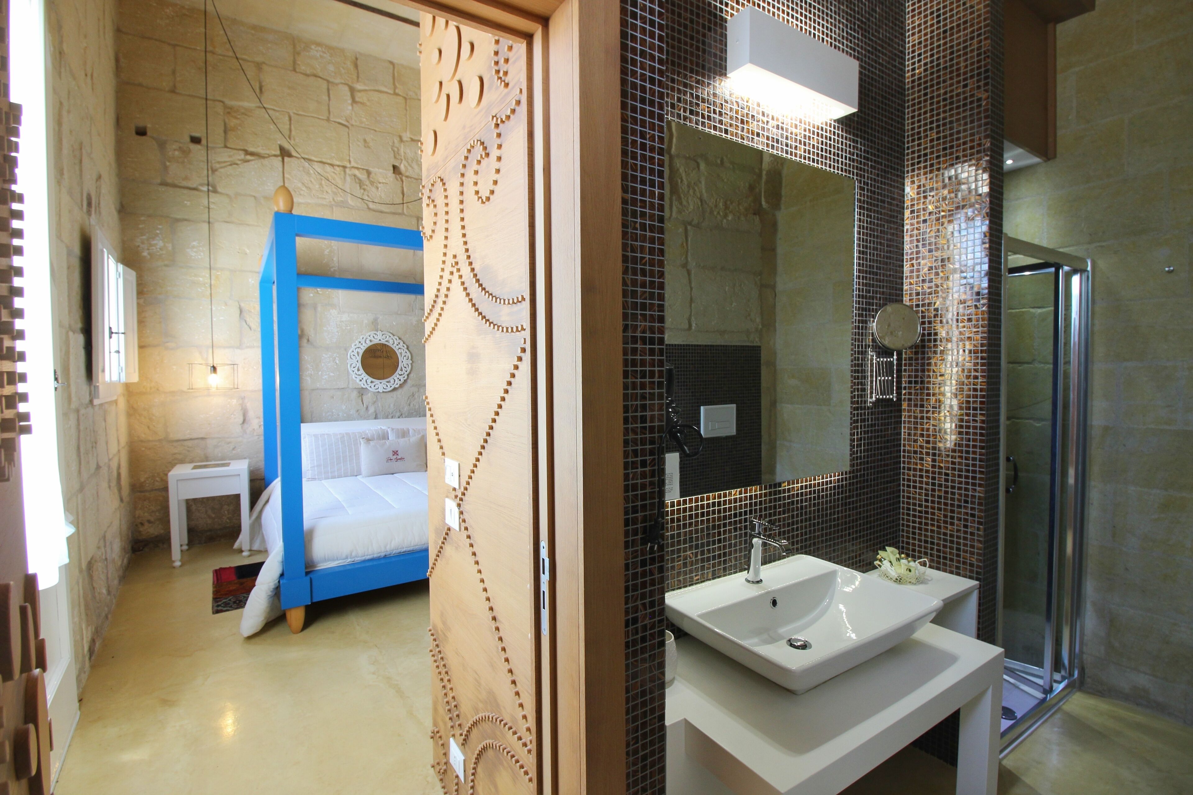 A modern bathroom with a large mirror, a sink, and a shower.