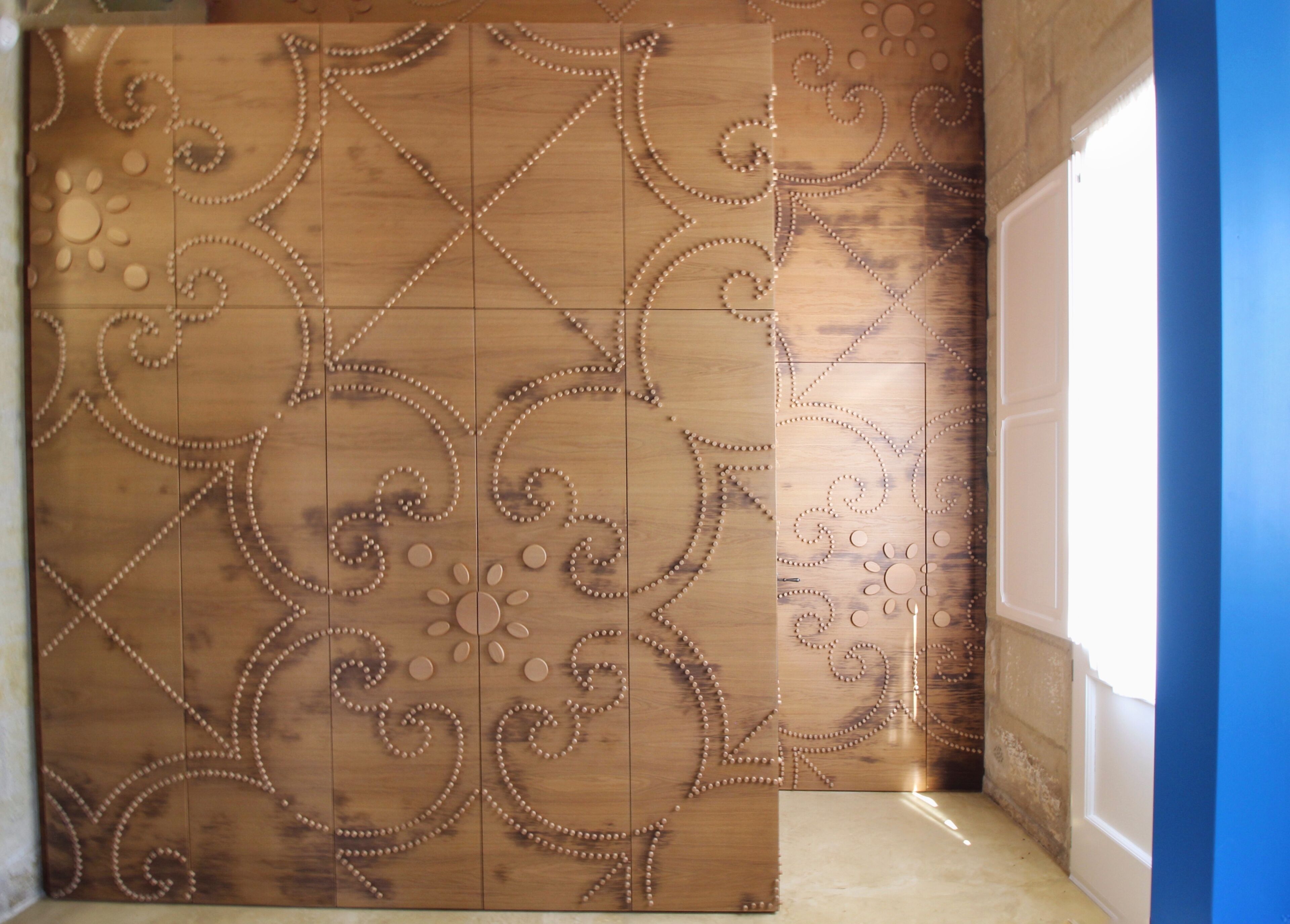 A wooden wall with intricate carvings and a door.