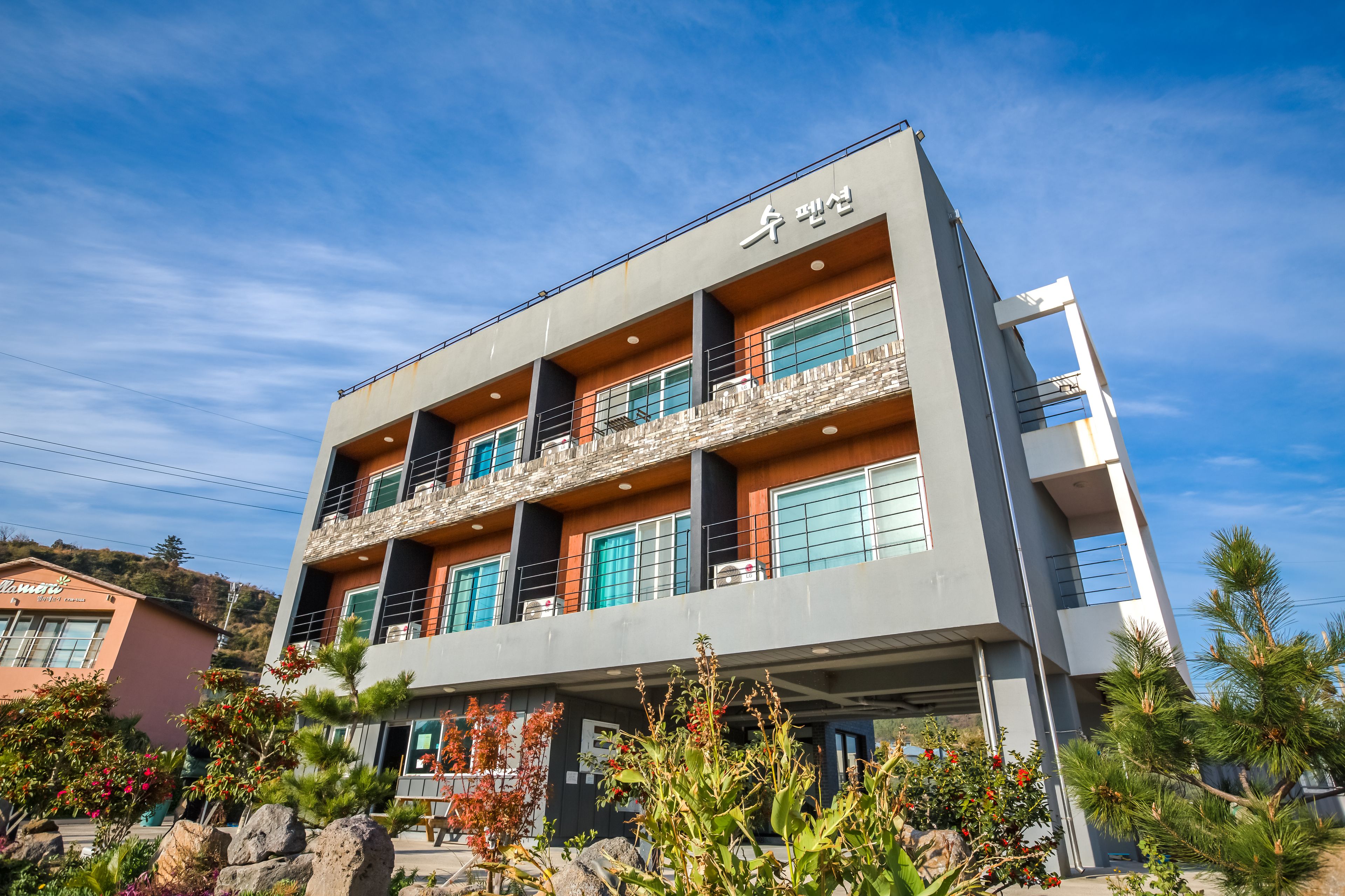 A modern building with a balcony, large windows, and a sign in a foreign language.