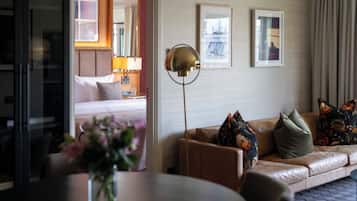 Una habitación de hotel con cama, sofá, lámpara de pie y mesa de comedor.