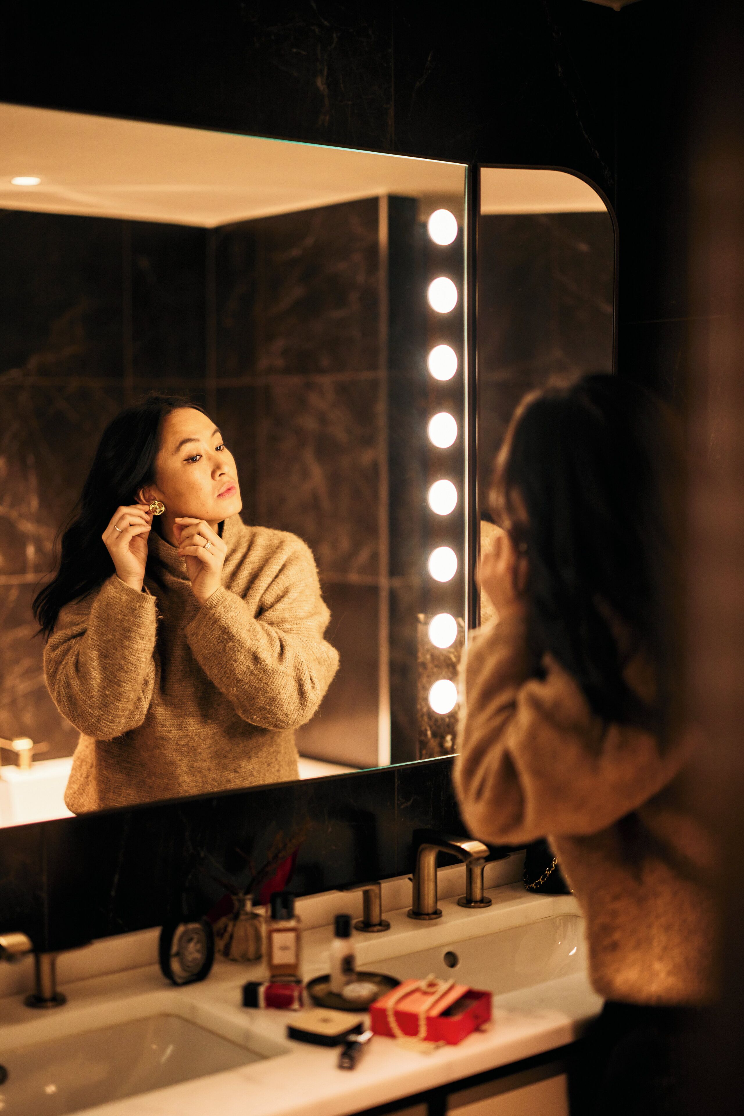 A bathroom with a mirror, sink, and lights.