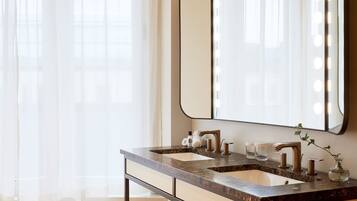 Un bagno con due lavabi, uno specchio grande e luci a specchio.