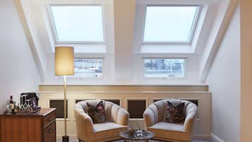 A room with two armchairs, a coffee machine, a lamp, and a view through skylights.