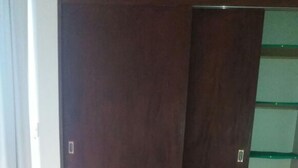 A bed with a pink and beige mattress in a room with tiled flooring and a wooden wardrobe. - Residencial Salinas (Florianópolis)