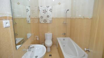 Un baño con lavamanos, inodoro y bañera.