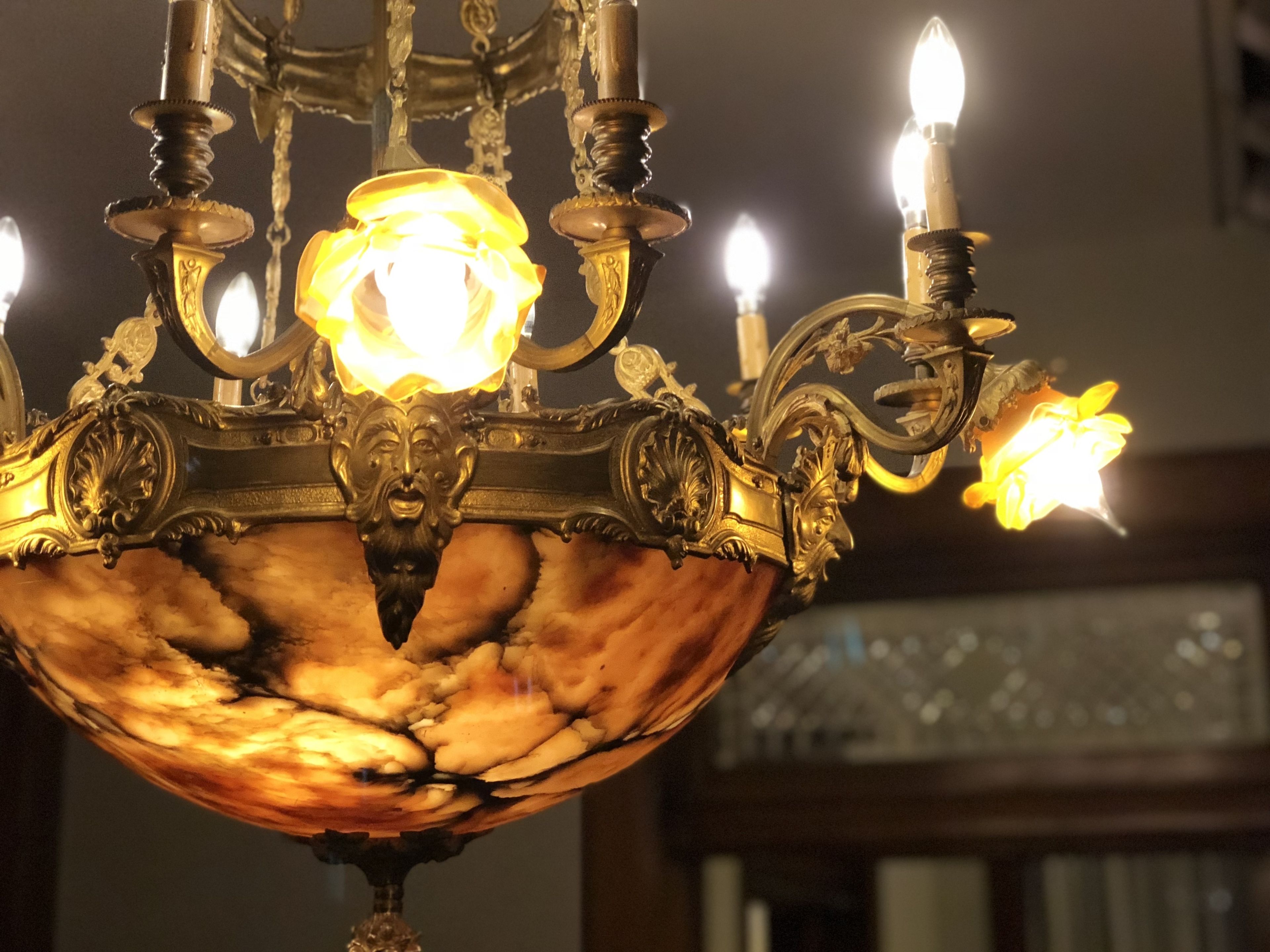 Un lustre orné de nombreuses bougies et doté de motifs métalliques complexes.