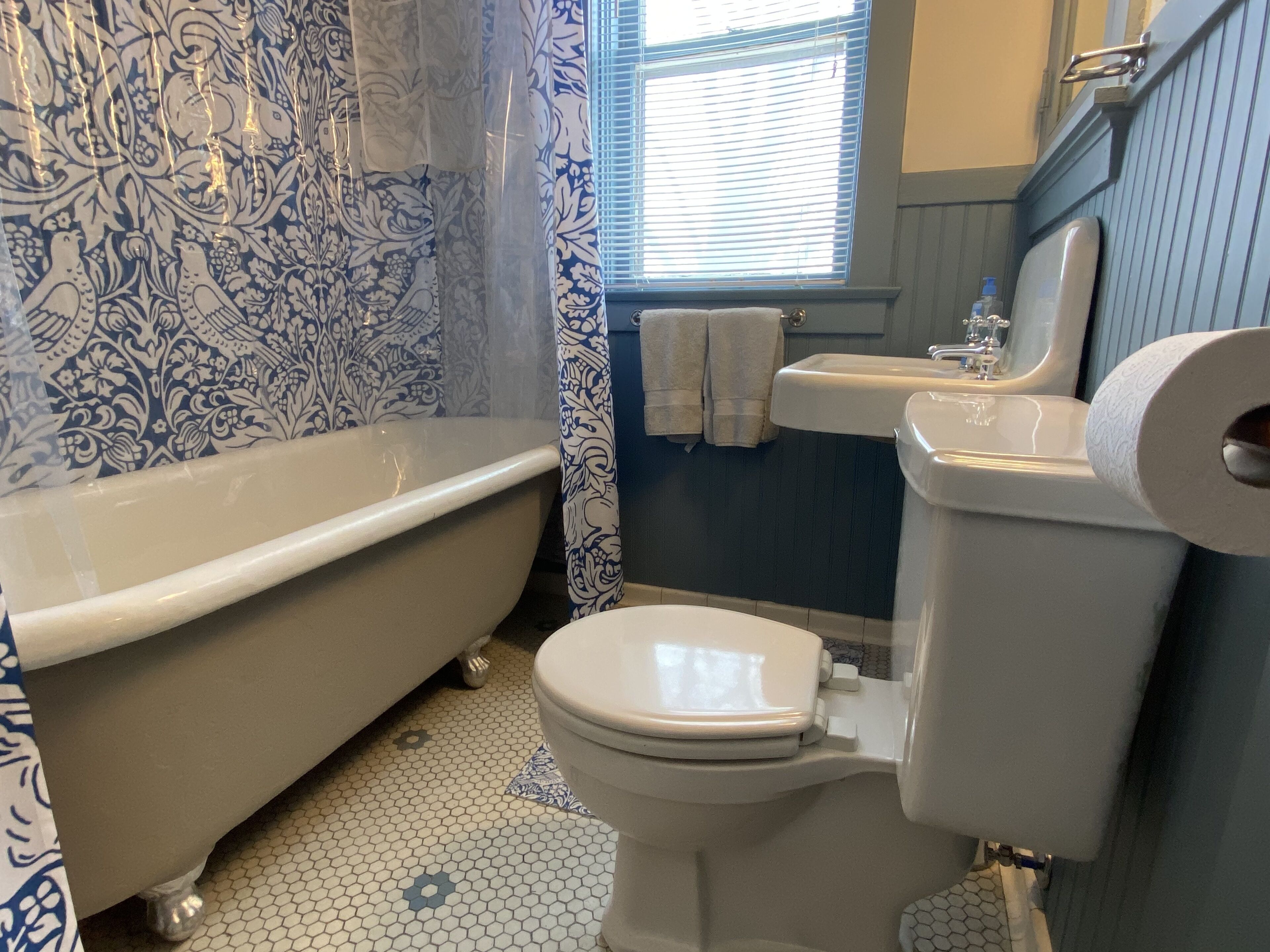 A bathroom with a clawfoot bathtub, a toilet, and a sink.