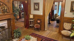 A traditional interior with a fireplace, wooden furniture, and a chandelier. - Vineyard Mansion & Carriage House Bed & Breakfast (St. Joseph)