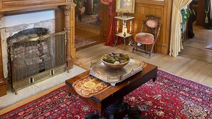 A traditional room with a fireplace, ornate chandelier, and classic furniture. - Vineyard Mansion & Carriage House Bed & Breakfast (St. Joseph)