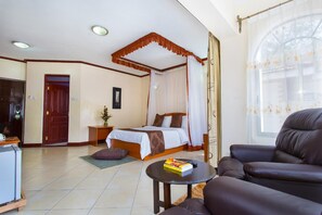 A hotel room with a bed, a desk, a chair, and a window with curtains. - Convent International Hotel Nairobi (Nairobi)
