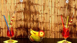 A bar area with two cocktail glasses on the counter, a bowl of fruit, and a water feature below. - Schacht85 (Oberhausen)
