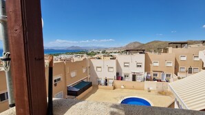 Un quartier résidentiel avec des immeubles, une piscine et une vue dégagée sur la mer et les montagnes.