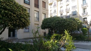 A building with multiple balconies, a small garden area with various plants, and a clear view of the surrounding environment. - 2 rooms Full City Center, Clim WIFI Absolute Calm at 400 m Promenade des Anglai (Nice)