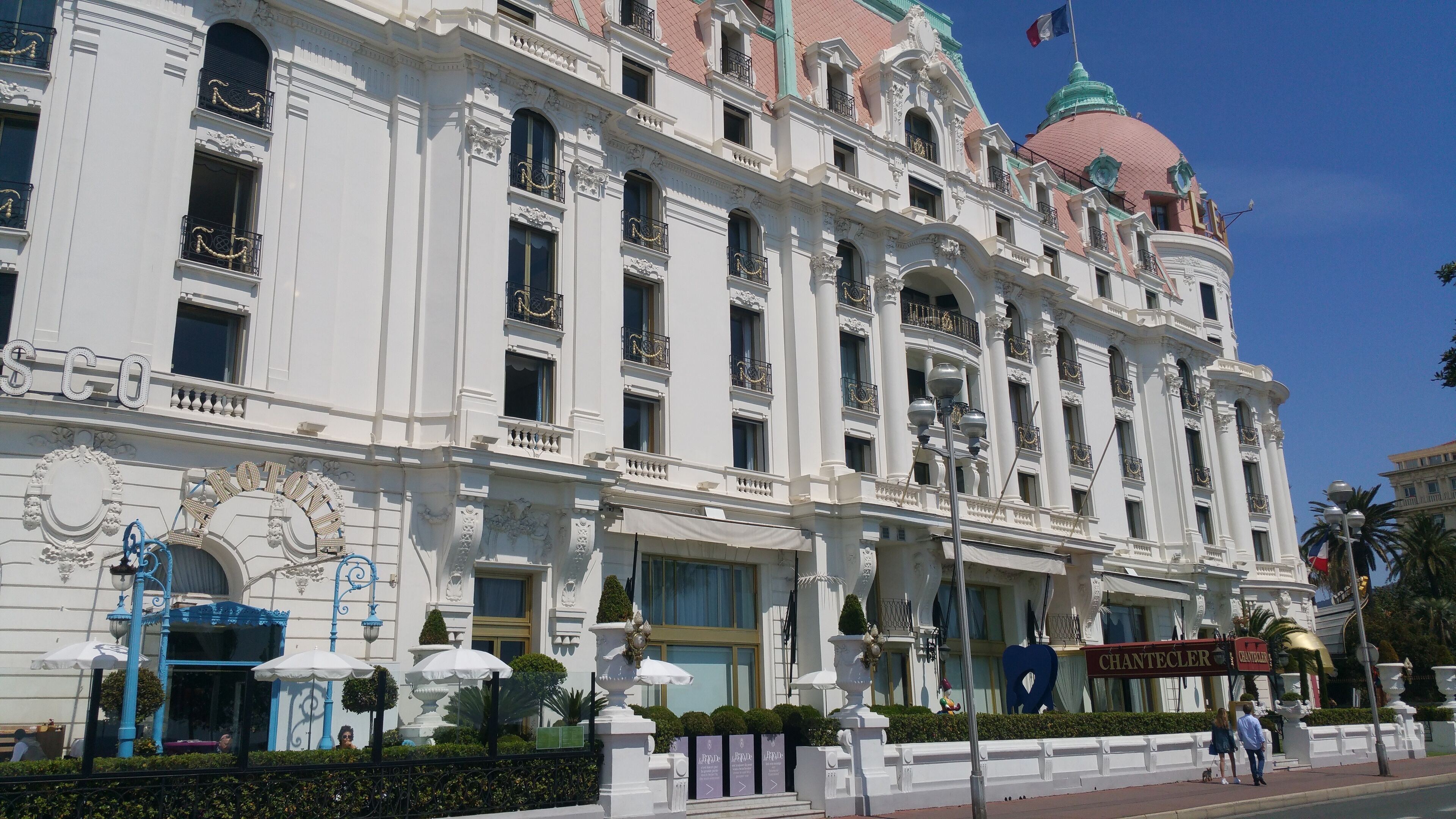 A large, ornate hotel with classical architecture, including columns and decorative balconies.