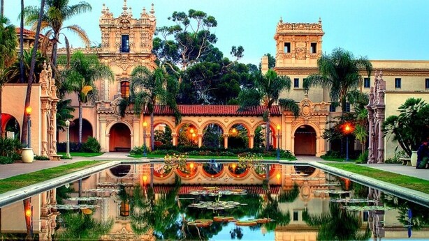 A historic building with ornate architecture, a central courtyard with a reflective pool, and surrounding greenery. - Ocean Beach Sunset Cottage - Steps to Shoreline (San Diego)