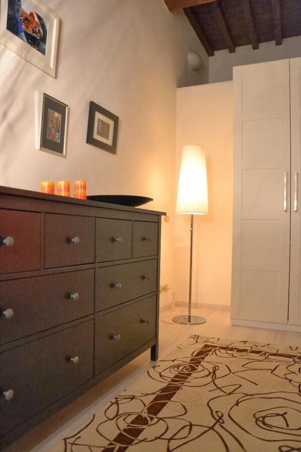 A room with a wooden dresser, a lamp, and a wardrobe.