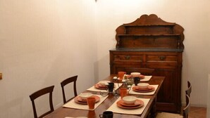 A dining area with a long wooden table set for four, surrounded by chairs with woven seats. - Enchanting Florentine Gem: Perfect Location! (Firenze)